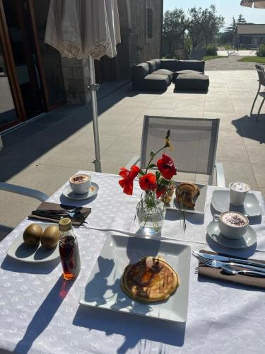a table with plates of food and flowers on it at Villa Paladini in Montefiascone