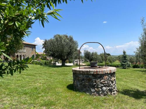 a stone fountain in the middle of a field at Villa Paladini in Montefiascone
