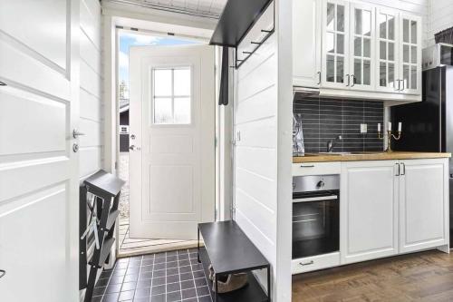 a kitchen with white cabinets and a white door at Loft ”Aurora” Ski Resort in Kåbdalis