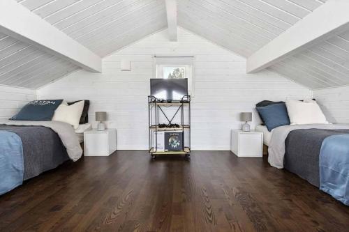 a bedroom with two beds and a television in it at Loft ”Aurora” Ski Resort in Kåbdalis