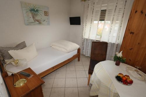 Habitación pequeña con cama y mesa con fruta. en Hotel Linde, en Speyer