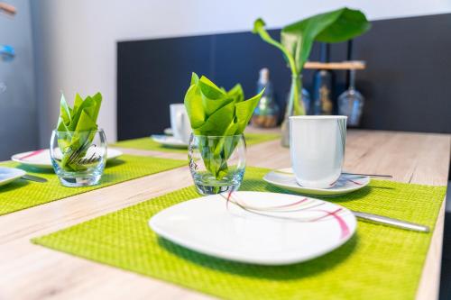 a table with plates and cups and plants on it at Ferienvilla Koblenz in Koblenz