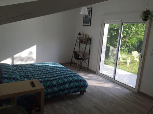 a bedroom with a bed and a sliding glass door at studio avec jardin en campagne in Le Thor