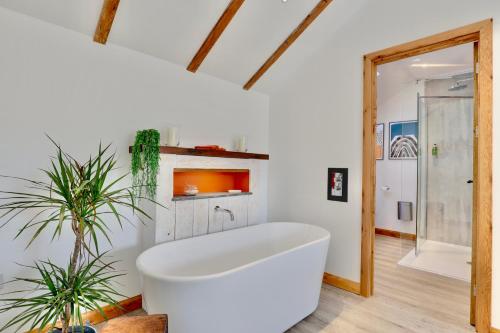 a bathroom with a white tub in a room at The Owl Barn Wiltshire - Chalk in Swindon