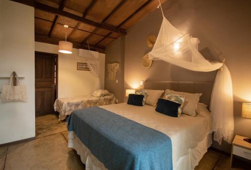 a bedroom with a bed with a mosquito net on it at Bonito Paraiso Ilha Grande in Abraão