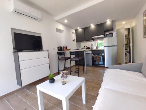 un salon avec un canapé blanc et une table dans l'établissement Charmant Studio Lavandou - 500m plage, au Lavandou