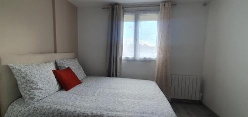 a small bedroom with a bed with a red pillow at Studio Grand Confort à Houilles in Houilles