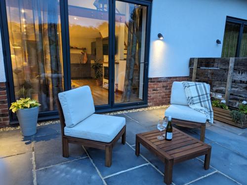 two chairs and a coffee table on a patio at The Owl Barn Wiltshire - Chalk in Swindon