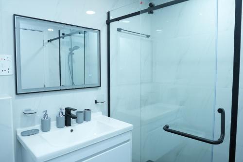 a white bathroom with a sink and a shower at Shams JBR Hostel in Dubai