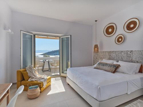 a white bedroom with a bed and a balcony at Private Luxury Scarlet beachfront villa, Molos, Paros in Molos Parou