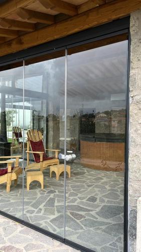 モンテフィアスコーネにあるVilla Paladiniのガラス窓のあるパティオ(椅子、テーブル付)
