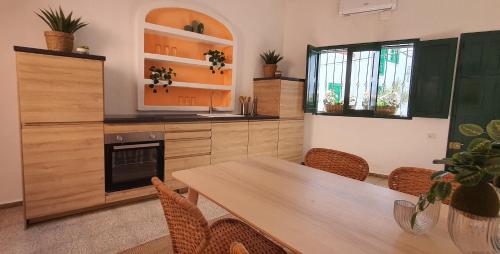 a kitchen with a wooden table and a dining room at Puerto Mogan Casa Feliz in Puerto de Mogán