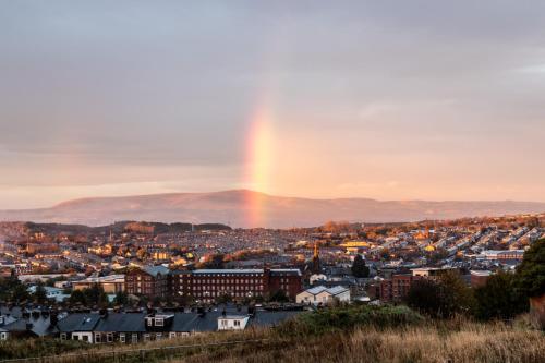 a rainbow in the sky over a city at Modern 2-Bedroom Loft Apartment - Pendle Hill & Ribble Valley Views - Free Parking in Church