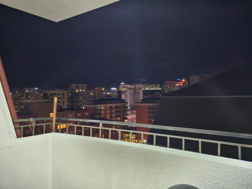 a view of a city at night from a balcony at Sara's cozy apartment in Pristina