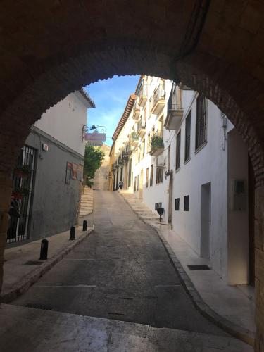 an archway in an alley with white buildings at RichMarHome in Pego