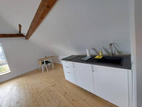 uma cozinha com lavatório e piso em madeira em Kinderklinik Dachwohnung Lion's Head 1B em Siegen