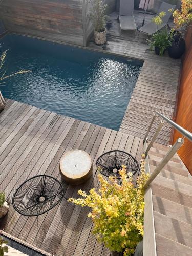 a pool with a table and chairs on a wooden deck at NEOZONE Neostudio Malmedy in Malmedy