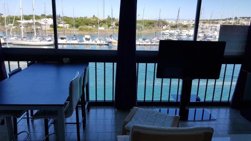 Zimmer mit einem Tisch und Stühlen sowie Hafenblick in der Unterkunft T3 70 m2 standing Cap d'Agde 4-6 pers in Cap d'Agde