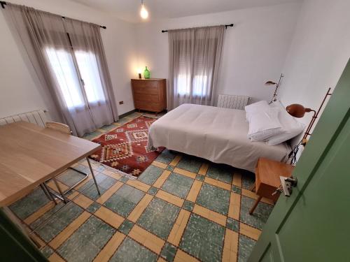 Schlafzimmer mit einem Bett, einem Tisch und Fenstern in der Unterkunft Casa rural El Moral in Huerta del Marquesado