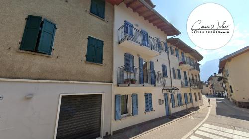 a building with blue shuttered windows and a garage at Appartamenti Bion in Levico Terme