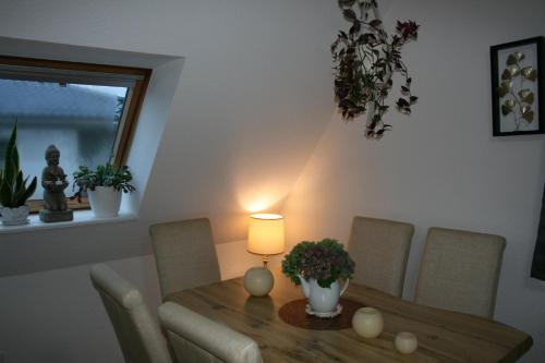 a dining room table with a lamp and some plants at Ferien Oase am BER in Schönefeld