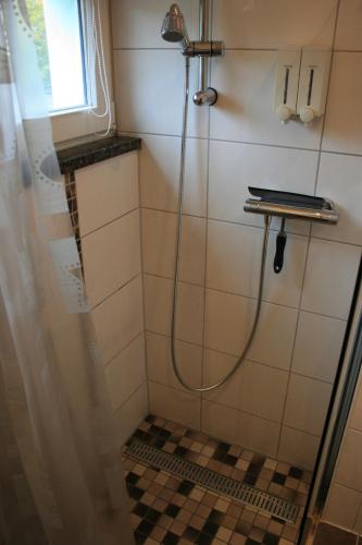 a shower in a bathroom with a tiled floor at Ferien Oase am BER in Schönefeld