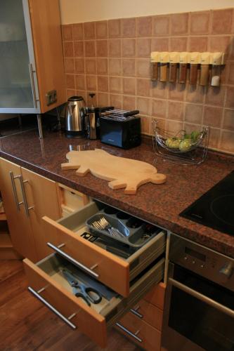 a kitchen counter with a cutting board in an open drawer at Ferien Oase am BER in Schönefeld