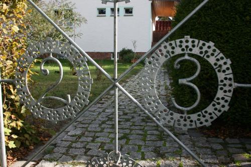 a metal gate with two numbers on a sidewalk at Ferien Oase am BER in Schönefeld