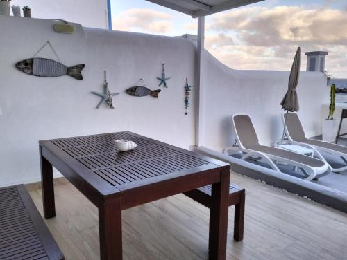 un soggiorno con tavolo, sedie e parete di Ático Los Balcones a Santa Cruz de la Palma