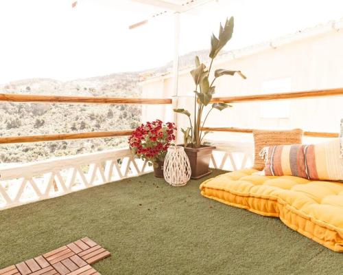 a balcony with two couches and a view of the mountains at la casita del pueblo PET friendly granada in Acebuches