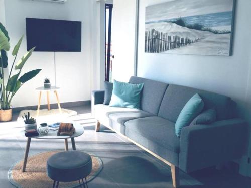 a living room with a blue couch and a table at Appartement centrum Calpé in Calpe