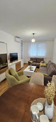 a living room with a couch and a table at SunShine Apartman CityBlock in Banja Luka