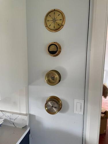 a white wall with two clocks on it at Lookout at Pleasant Bay with a private beach in Orleans