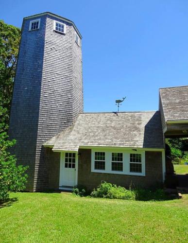 a brick house with a tower on top of it at Lookout at Pleasant Bay with a private beach in Orleans