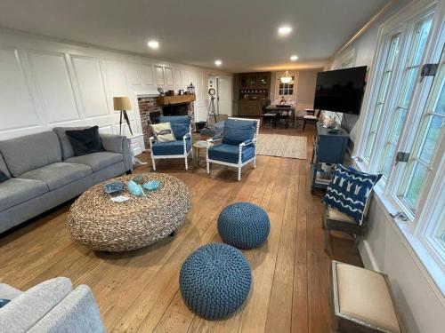 a living room with a couch and a table and chairs at Lookout at Pleasant Bay with a private beach in Orleans