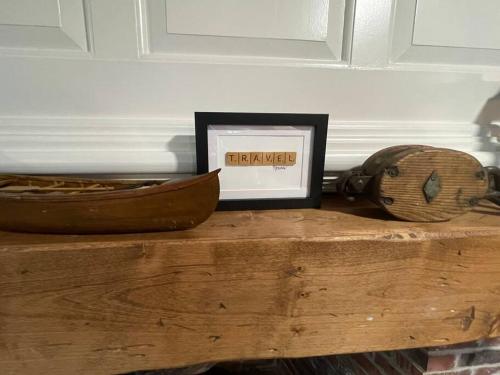 a picture frame and a basket on a wooden table at Lookout at Pleasant Bay with a private beach in Orleans
