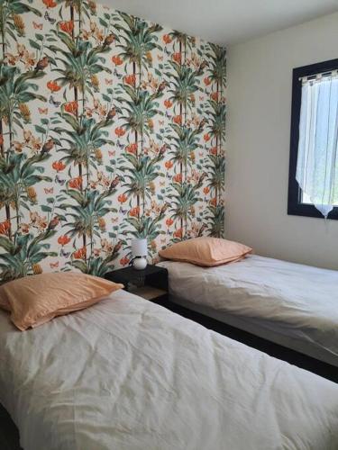 - 2 lits dans une chambre avec papier peint et palmiers dans l'établissement Villa Montélimar, à Montélimar