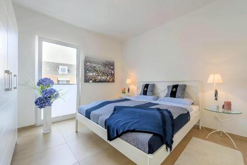 1 dormitorio con cama con sábanas azules y ventana en ٤Sweet Spot٤Geräumig-King Bed-Disney+-Parken, en Scharbeutz