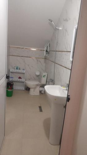 ein weißes Bad mit einem WC und einem Waschbecken in der Unterkunft New Rif Appartement Appelle moi 07 et 74 et 41 et 16 et 91 in Al Hoceïma