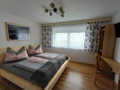 a bedroom with a bed and a large window at Apartment Marina in Wenns