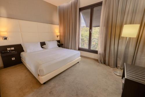 a bedroom with a bed and a large window at Lalla Doudja Hotel in Alger