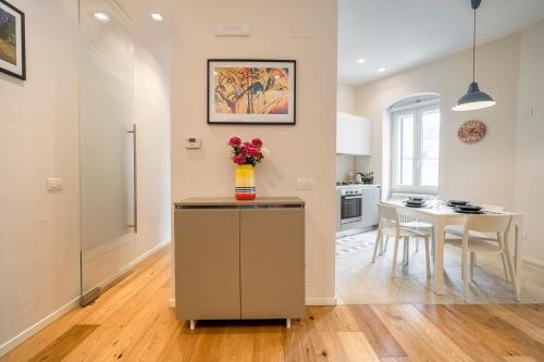 una cucina e una sala da pranzo con tavolo e vaso di fiori di martini apartment a Matera