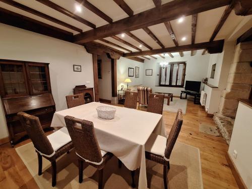 uma sala de jantar com uma mesa branca e cadeiras em APARTAMENTOS PALACION DE SANTILLANA em Santillana del Mar