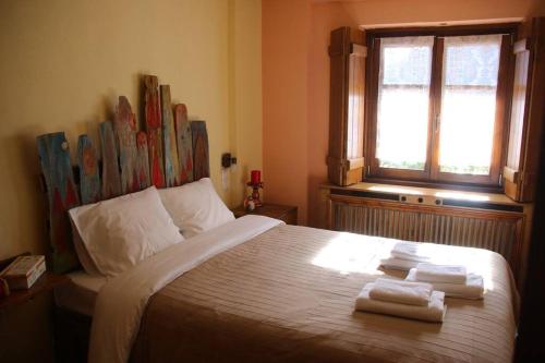 1 dormitorio con 1 cama con 2 toallas en Cozy Mountain Cabin, en Karpenisi