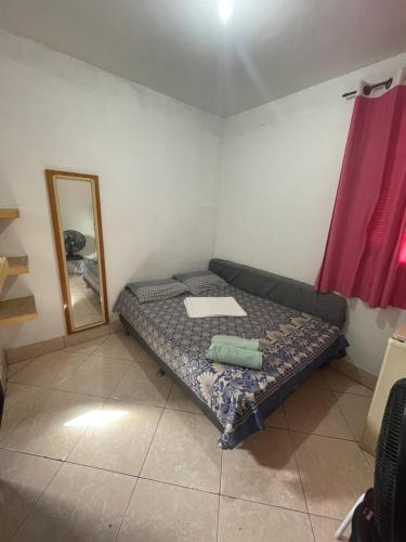 a small room with a bed and a mirror at Renan suítes in Arraial do Cabo