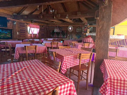 un restaurante con mesas y sillas rojas y blancas a cuadros en Pavlovica konaci, en Kotraža