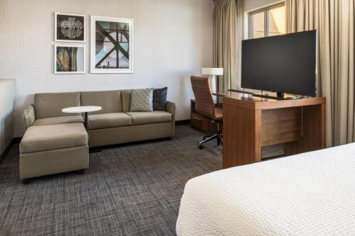 a hotel room with a couch and a flat screen tv at Residence Inn by Marriott Portland Downtown/Pearl District in Portland