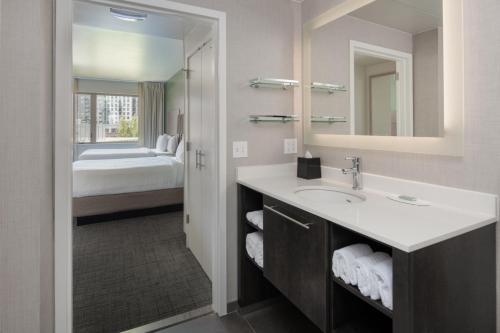 a bathroom with a sink and a bed at Residence Inn by Marriott Portland Downtown/Pearl District in Portland