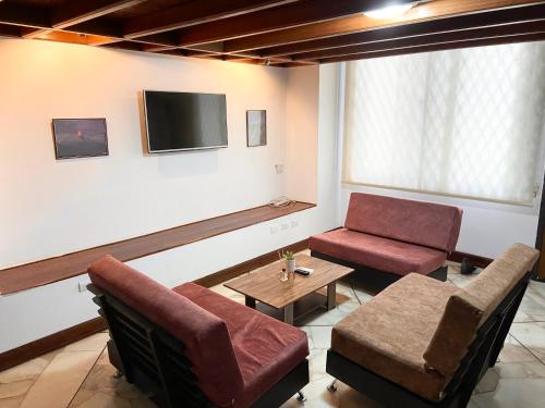 a living room with a couch and a table and a tv at Departamento Cómodo Frente a la Playa in Manta
