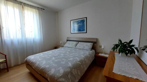 ein Schlafzimmer mit einem Bett und einer Topfpflanze in der Unterkunft Castagnole Apartment in Castagnole